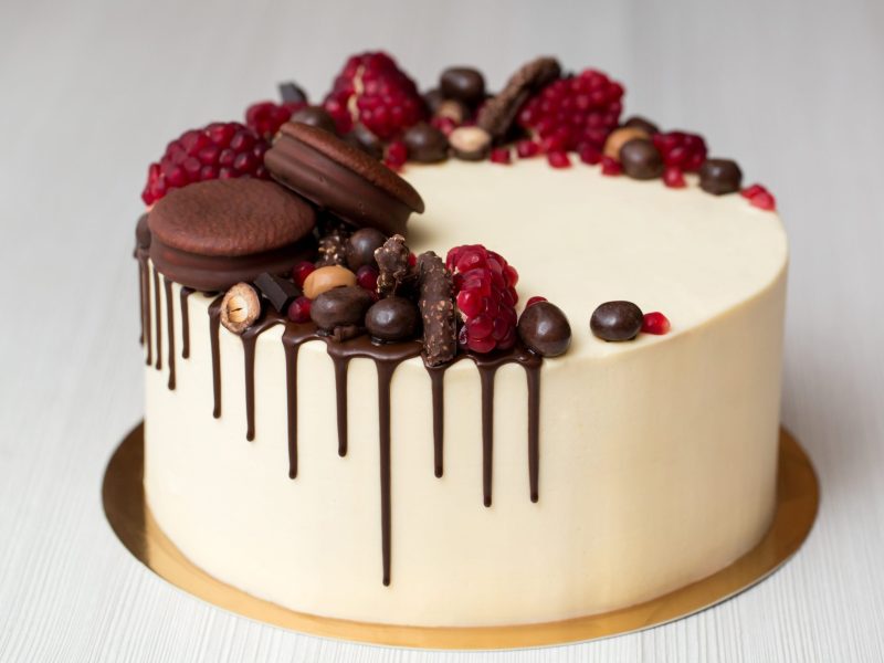 cake-with-white-cream-chocolate-drips-pomegranate-nuts-chocolate-decor-min
