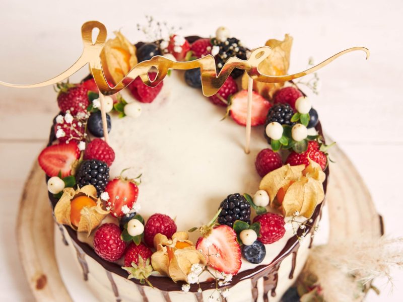 beautiful-wedding-cake-with-fruits-chocolate-drip-with-love-letters-min